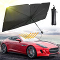 Black umbrella with carrying case over a red car on a scenic background